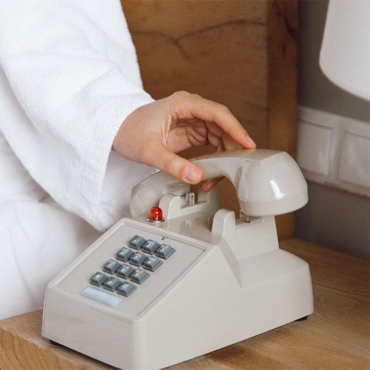 Telephone being picked up on a bedside cabinet